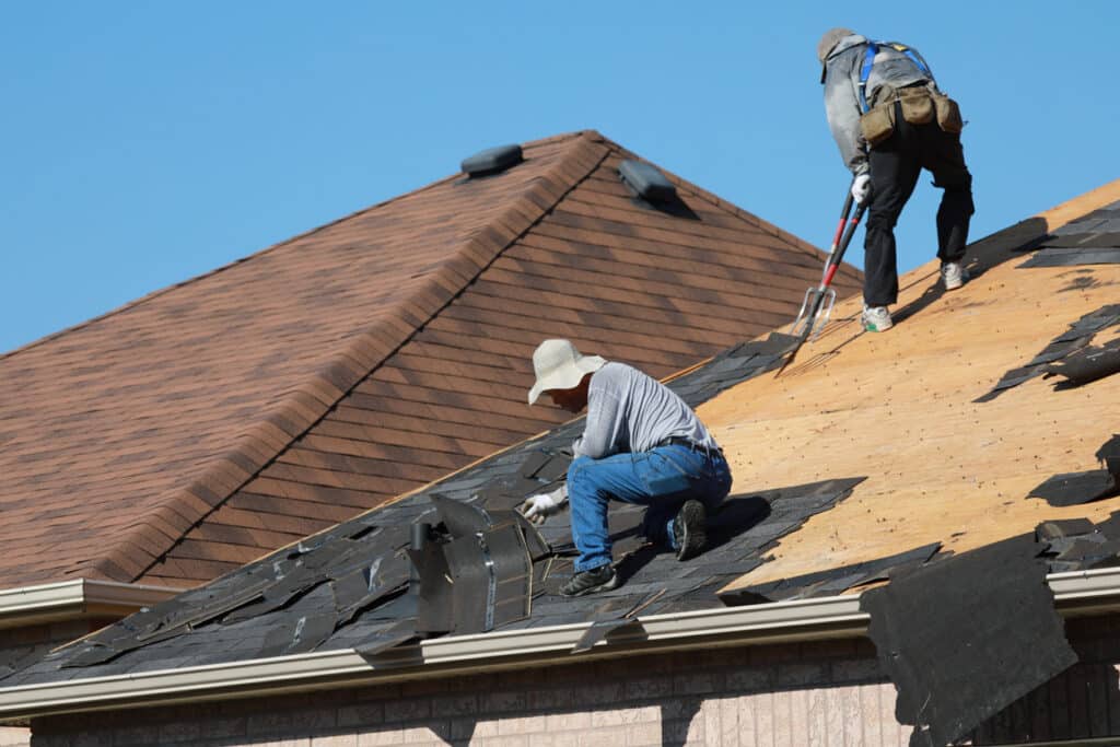 Roofers removing old shingles